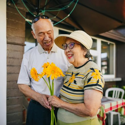 Elderly Couple Holding Bouquet of Flowers while Holding Hands